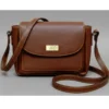 Compact caramel brown genuine leather flap bag with grain texture and long adjustable shoulder strap