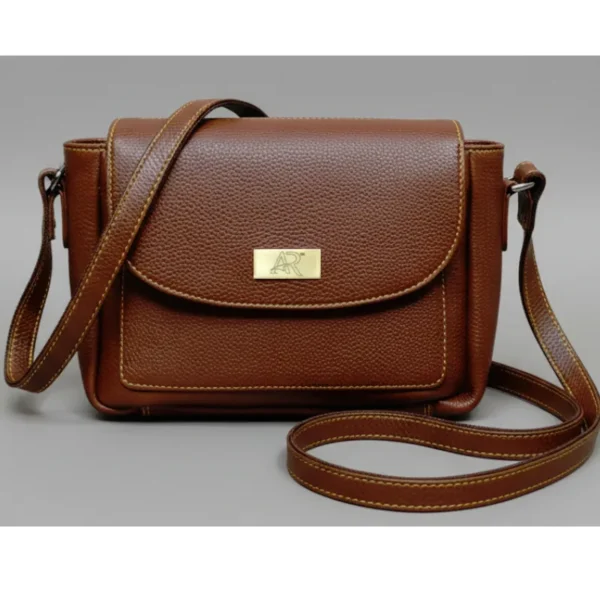 Compact caramel brown genuine leather flap bag with grain texture and long adjustable shoulder strap